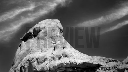 Sandstone Formation with Clouds is a black and white stock photograph.